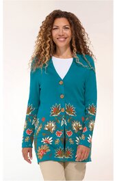 Türkisfarbener Cardigan mit floralem Muster in Rot, Beige und Grün an Ärmeln und Saum, V-Ausschnitt, braune Knöpfe, langärmelig, getragen von stehender Frau mit offenen lockigen Haaren, gerade geschnitten