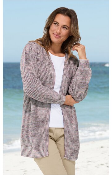 Offene Strickjacke in Grau-Rosé mit feinem Strukturmuster, lange Ärmel, gerader Schnitt, leicht verlängert, getragen von stehender Frau am Strand, ohne Verschluss