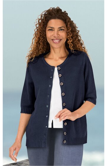 Dunkelblaue Strickjacke mit kurzen Ärmeln und Knopfleiste, rundem Ausschnitt, gerader Schnitt, getragen von lächelnder Frau mit locker offenen Haaren, darunter weißes Oberteil