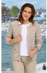 Beige Strickjacke mit Rundhals, Knopfleiste, langen Ärmeln, lockere Passform, getragen von stehender Frau vor Wasser und Felsen im Hintergrund