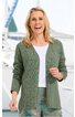 Olivgrüne offene Strickjacke ohne Verschluss, lange Ärmel, gerade geschnitten, getragen von lächelnder stehender Frau mit weißen T-Shirt und gemusterten grünen Hosen, Hintergrund mit Segelboot