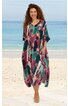 Maxikleid in dunklem Türkisgrün mit buntem abstraktem Muster in Rosa, Lila und Orange, V-Ausschnitt mit Knopfleiste, kurze weite Ärmel, Seitentaschen, lockere weite Passform, getragen von stehender Frau am Strand