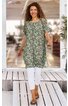 Grünes Tunika-Kleid mit floralem Muster in Beige und Weiß, rundem Ausschnitt, kurze Ärmel, knielang, locker geschnitten, getragen von stehender Frau, trägt weiße Leggings und braune Sandalen