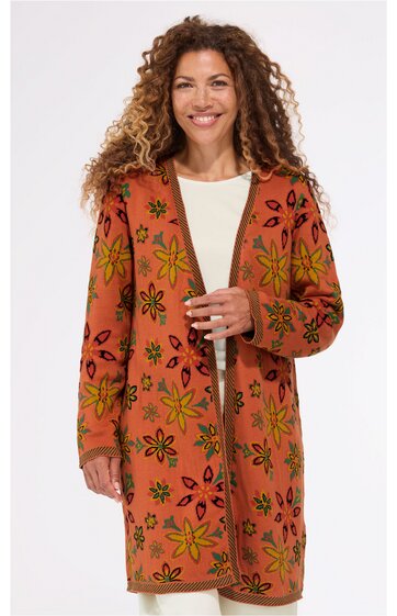 Langer, kastanienbrauner Cardigan mit großem, floralen Muster in Gelb und Schwarz, offener Schnitt ohne Verschluss, lange Ärmel, getragen von lächelnder stehender Frau