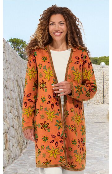 Langer, kastanienbrauner Cardigan mit großem, floralen Muster in Gelb und Schwarz, offener Schnitt ohne Verschluss, lange Ärmel, getragen von lächelnder stehender Frau