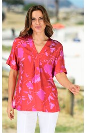 Rotes Damenblusenshirt mit pinkem Blumenmuster, V-Ausschnitt, halblange Ärmel, lockere Passform, getragen von stehender Frau, leichte Falten am Ausschnitt