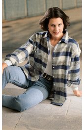 Hemdjacke, beige mit dunkelblauen großen Karos, langärmlig, Kragen, Knopfleiste, locker sitzend, getragen von sitzender Frau mit blauen Jeans, schwarze Gürtel