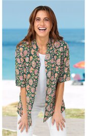 Grünes Hemd mit kurzärmeligem Blumenmuster in Rosa und Hellgrün, Kragen, offen getragen über weißem T-Shirt, an stehender Frau am Strand