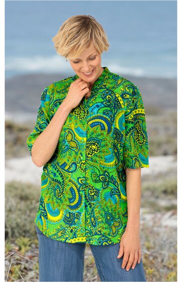Grüne Bluse mit blauem und gelbem Paisleymuster, V-Ausschnitt mit Kragen, halblange Ärmel, gerade geschnitten, getragen von lächelnder stehender Frau mit kurzem blonden Haar