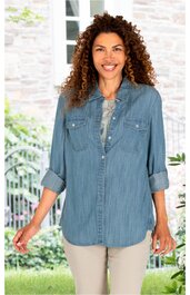 Jeansblaues Hemd, langärmlig, mit Knopfleiste, Brusttaschen, umgeschlagene Ärmel, gerade geschnitten, getragen von stehender Frau vor hellem Hintergrund