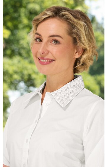 Weiße Bluse mit Spitzenkragen, durchgehende Knopfleiste, langärmlig, getragen von lächelnder Frau, gerade geschnitten