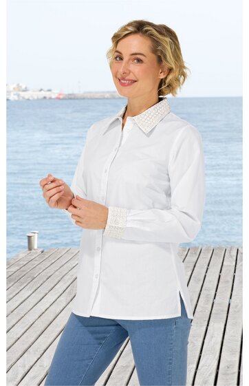 Weiße Hemdbluse mit Langarm, klassischem Kragen, verdeckter Knopfleiste, seitlichen Schlitzen, getragen von lächelnder stehender Frau vor Wasser und Holzsteg