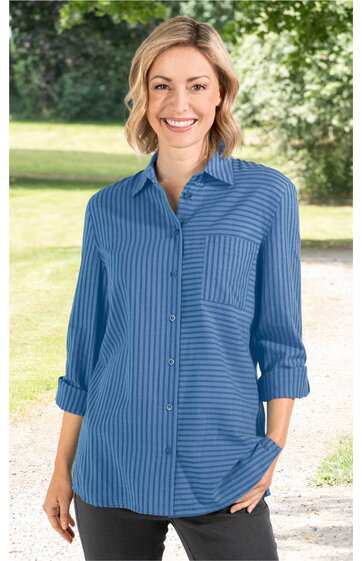 Blau gestreifte Bluse mit Hemdkragen, durchgehender Knopfleiste, aufgesetzter Brusttasche, lange Ärmel mit Umschlag, getragen von stehender Frau im Freien