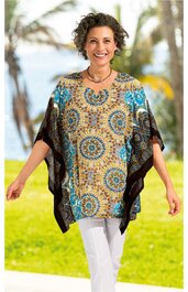 Weit geschnittene Tunika in Hellbraun mit blauem und schwarzem Mandala-Muster, halblange breite Ärmel, rundhals, getragen von lächelnder stehender Frau, locker fallend
