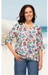 Weiße Bluse mit buntem Blumenmuster in Rot, Blau und Grün, V-Ausschnitt, halblange Ärmel mit Kordelzug, locker geschnitten, getragen von stehender Frau, casual Look