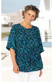 Damenbluse in dunkelblau mit kleinem hellblauem Blumenmuster, Rundhalsausschnitt, lockere Passform, kurze Ärmel, getragen von lächelnder stehender Frau