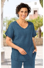 Damen-T-Shirt in dunklem Blau mit feinem Karomuster, rundem Ausschnitt, lockere Passform, kurze Ärmel, zwei Seitentaschen, getragen von stehender Frau im Freien