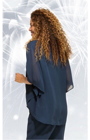 Dunkelblaue Chiffonbluse ohne Muster, lange weit geschnittene Ärmel, lockerer gerader Schnitt, Rückenansicht, getragen von stehender Frau mit lockigen langen Haaren