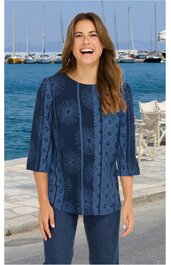 Damenoberteil in dunklem Blau mit grafischem Muster, Rundhalsausschnitt, 3/4-Ärmel, gerade geschnitten, getragen von stehender Frau vor Hafen mit Wasser und Segelbooten