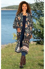 Langer Kimono in Dunkelblau mit großflächigem Blumenmuster in Orange und Beige, offener Schnitt, lange Ärmel, getragen von entspannter Frau stehend im Freien, leichte und offene Passform