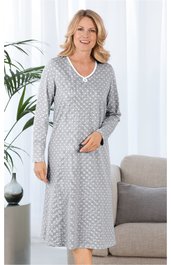 Hellgraues Nachthemd mit weißen Punkten, V-Ausschnitt mit weißem Besatz, lange Ärmel, knielang, gerade geschnitten, getragen von stehender Frau, weicher fallender Stoff