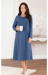 Langärmeliges Nachthemd in Blau, Knopfleiste am Rundhalsausschnitt, weite Passform, knöchellang, getragen von stehender Frau, hält weiße Tasse in rechter Hand