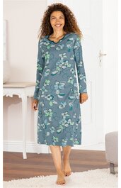 Nachthemd in mittlerem blaugrün mit floralem Muster in Hellgrün und Weiß, rundem Halsausschnitt, lange Ärmel, knielang, locker sitzend, getragen von lächelnder stehender Frau