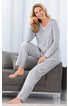 Grauer Pyjama mit weißem Punktemuster, langer Arm, V-Ausschnitt mit Knopfdetail, lange Hose, getragen von sitzender Frau auf grauem Sofa