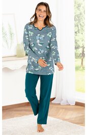 Zweiteiliger Damen-Schlafanzug, oberteil in blaugrau mit großem floralem Muster in Weiß und Hellgrün, Rundhalsausschnitt, lange Ärmel, Hose einfarbig petrolblau, gerade geschnitten, getragen von lächelnder stehender Frau