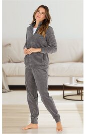 Damen-Jogginganzug in mittlerem Grau, einfarbig, langärmlige Jacke mit Stehkragen und Reißverschluss, passende Hose mit elastischen Bündchen, getragen von stehender Frau mit leicht verschränkten Händen