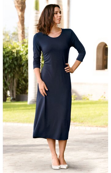 Dunkelblaues, knöchellanges, eng anliegendes Kleid mit 3/4-Ärmeln und rundem Ausschnitt, getragen von stehender Frau mit einer Hand in der Hüfte, glatte Oberfläche, schlichtes Design