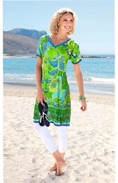 Kleid in Hellgrün und Blau mit Paisley-Muster, V-Ausschnitt, kurze Ärmel, knielang, getragen von stehender Frau am Strand, figurbetont