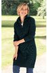 Dunkelblaues Strickkleid mit hohem Stehkragen, lange Ärmel, knielang, schmal geschnitten, getragen von lächelnder stehender Frau vor grüner Außenkulisse