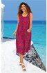 Ärmelloses midikleider in magenta mit rotem Blumenmuster, weiter Rundhalsausschnitt, seitliche Eingrifftaschen, ausgestellte Form, getragen von stehender Frau mit offenen Locken, weiße Sandalen, Strandkulisse