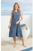 Blaues ärmelloses Kleid mit weißem Blütenmuster, Rundhalsausschnitt, knielang, ausgestellter Rock, getragen von stehender Frau in Sandalen