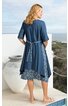 Dunkelblaues Freizeitkleid mit halbhohen Ärmeln, darunter hellblauer Rock mit weiß-blauem Blumenmuster, lockere Passform, Bindegürtel hinten, knieumspielend, getragen von stehender Frau mit Blick zur Seite