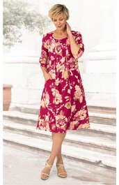 Knielanges Kleid in dunklem Rot mit großflächigem hellbeigem Blumenmuster, halblange Ärmel, runder Ausschnitt mit kleiner Knopfleiste, tailliert, getragen von Frau in Stehpose, seitliche Taschen