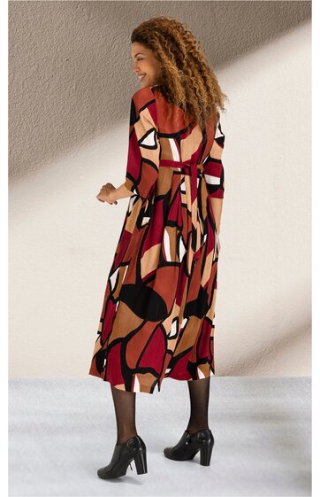 Midikleid in Rot, Schwarz, Beige und Weiß mit abstraktem Muster, Dreiviertelärmel, offenem Rückenausschnitt mit Schleife, locker fallend, getragen von stehender Frau mit schwarzen Schuhen und Strumpfhose