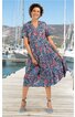 Midikleid in Blau mit rosa und schwarzen Blumenmustern, V-Ausschnitt, kurze Ärmel, lockere Passform, ausgestellter Rock, getragen von lächelnder Frau auf Steg vor Yachten, mit blauen Schuhen und Knöchelriemen