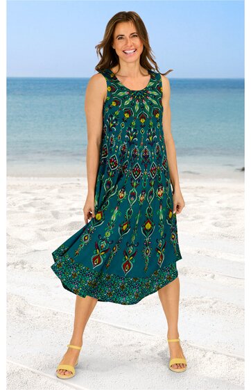 Ärmelloses Maxikleid in türkisgrün mit buntem Ethno-Muster, Rundhalsausschnitt, lockere lange Form, getragen von stehender Person am Strand, leichte Stoffstruktur sichtbar
