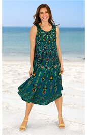 Ärmelloses Maxikleid in türkisgrün mit buntem Ethno-Muster, Rundhalsausschnitt, lockere lange Form, getragen von stehender Person am Strand, leichte Stoffstruktur sichtbar
