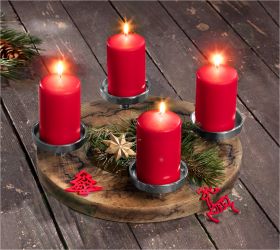 Adventskranz aus Holz mit vier brennenden roten Kerzen, grünen Tannenzweigen, goldfarbenem Stern und roten Filzornamenten in Baum- und Rentierform auf dunklem Holztisch