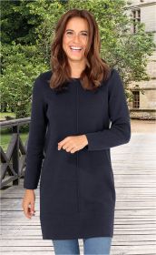 Frau trägt dunkelblaues, langärmeliges Baumwoll-Mix-Kleid bis Mitte Oberschenkel, steht lachend auf Holzsteg mit grünen Bäumen und altem Steinbau im Hintergrund