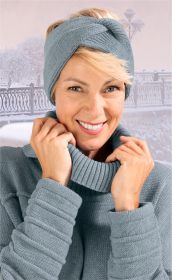 Frau mit blondem Haar trägt graues gestricktes Baumwoll-Mix-Stirnband und passenden Pullover, hält den Kragen des Pullovers, im Hintergrund winterliche Parkszene mit Schnee und Laternen.