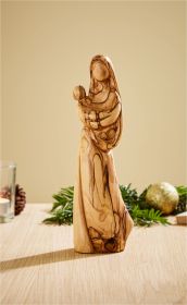 Olivenholz-Skulptur einer stilisierten Madonna mit Kind, glatte Oberfläche, natürliche Holzmaserung, stehend auf Holzuntergrund, dekorative Tannenzweige und Weihnachtskugeln im Hintergrund