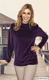 Frau mit schulterlangen blonden Haaren trägt ein lila Baumwoll-Shirt mit langem Arm, steht lächelnd vor einem Holzsteg am Wasser, eine Hand an der Hüfte, die andere auf einem Geländer abgestützt