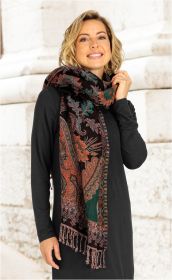 Frau trägt langen Jacquard-Schal mit floralem Muster in Braun, Orange und Grün, der locker um den Hals drapiert ist, vor hellem Mauerhintergrund, schwarzes Kleid, lächelnd, rechte Hand hält Schal am Hals