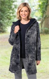 Frau trägt graue Wollmix-Jacke mit Kapuze und Knöpfen, kombiniert mit schwarzem Pullover und grauer Hose, stehend in natürlicher, grüner Parkumgebung, lächelnd