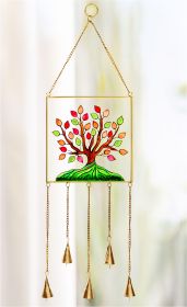 Fensterbild mit farbigem Baum-Motiv in Rot, Orange und Grün, Rahmen und Ketten in Gold, fünf Glocken hängen an goldenen Ketten unten, helles unscharfes Hintergrundlicht