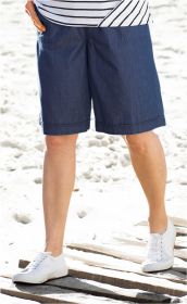 Person trägt dunkelblaue Baumwoll-Hose bis knapp über die Knie, kombiniert mit weiß-blau gestreiftem Oberteil und weißen Sportschuhen, steht auf einem sandigen Untergrund mit hölzernen Dielen.